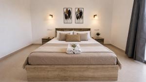 a bedroom with a large bed with two white shoes at Balis Villa Naxos in Agios Prokopios