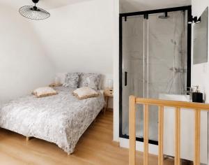 a bedroom with a bed and a shower and a sink at Le Duplex Port & Plage in Dieppe