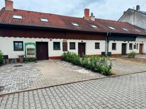 a white house with a red roof and a patio at Apartment sklep 33E in Hrušky