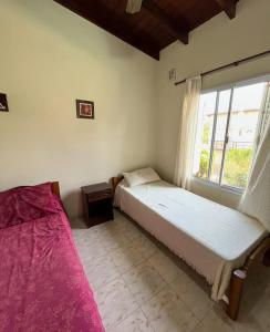 a bedroom with two beds and a window at Amanecer y Canela in Mina Clavero