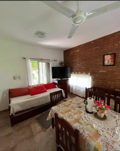a living room with a bed and a couch and a table at Amanecer y Canela in Mina Clavero +5 photos