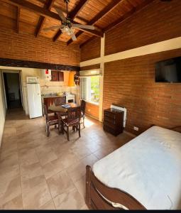 a bedroom with a bed and a table and a kitchen at Amanecer y Canela in Mina Clavero