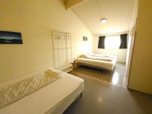 a small room with two beds and a window at Kaldbakur Guesthouse in Heimaland
