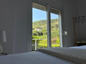 a bedroom with a bed and a large window at Ilvi Guesthouse in Gjirokastër +28 photos