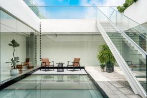 a glass house with two chairs and a table at 微云隐舍 in Jiazaiwei