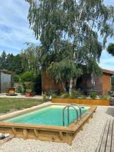 a swimming pool in a yard with a wooden deck at Ecogîte Les Papillons des Sucs in Saint-Maurice-de-Lignon