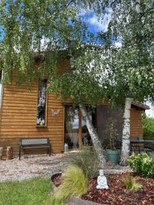 a house with a bench and a tree in the yard at Ecogîte Les Papillons des Sucs in Saint-Maurice-de-Lignon