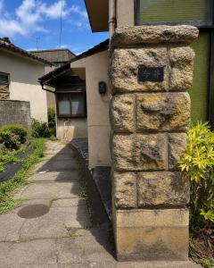 a stone wall on the side of a house at Guesthouse今井邸 in Tonami