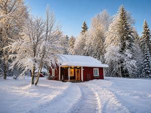 a small red cabin in the snow with trees at HomeSweetSweden in Malung