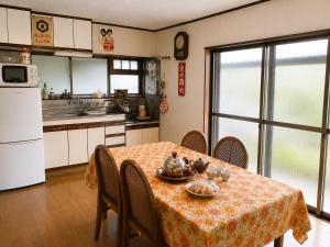 a kitchen with a table with a table cloth on it at Guesthouse今井邸 in Tonami