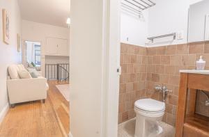 a bathroom with a toilet and a living room at Charm 2Bd in Upper East Side with Backyard in New York +20 photos