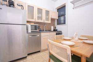 a kitchen with a wooden table and a refrigerator at Charm 2Bd in Upper East Side with Backyard in New York