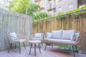 a patio with two chairs and a couch and a table at Charm 2Bd in Upper East Side with Backyard in New York