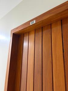 a wooden door with the number on top of it at Residencial Bom Sossego Apto 01 in Itabuna
