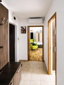 a kitchen and living room with a yellow chair at Adrian Home Libra in Ploieşti