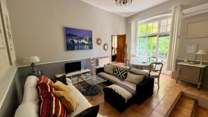 a living room with a couch and a tv at Entre vignes et dentelles in Courthézon