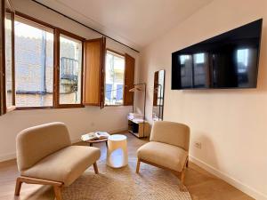 a living room with two chairs and a flat screen tv at YourHouse O Foxo in Allariz