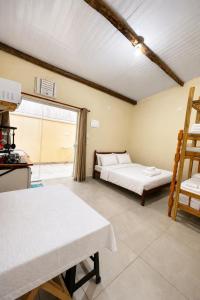 a room with two beds and a window at Chalés & Suítes Praia Barequeçaba I Cozinha Compacta in São Sebastião +8 photos