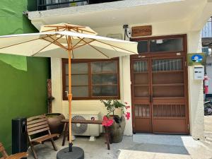 a table with an umbrella in front of a building at Lane 82 Homestay in Chiayi City