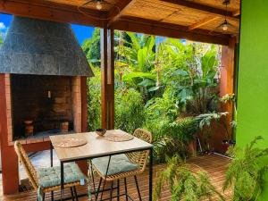 a patio with a table and chairs and a fireplace at Lodge Sakayu - Charme, calme & piscine privée in Saint-Louis