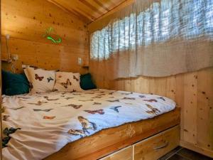 a bedroom with a bed in a log cabin at Ecogîte Les Papillons des Sucs in Saint-Maurice-de-Lignon