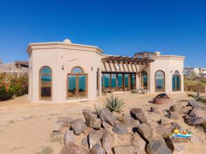 a house on the beach with rocks in front of it at Casa Serenity Beachfront Rental in San Felipe