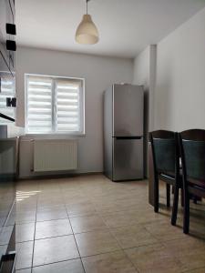 a kitchen with a refrigerator and a table and chairs at Adrian Home Libra in Ploieşti