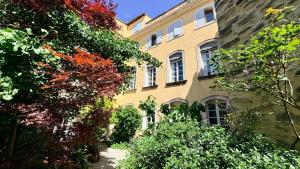 a building with trees and plants in front of it at Entre vignes et dentelles in Courthézon