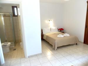 a bedroom with a bed and a shower and a toilet at Kato Zakros Palace Apartments in Kato Zakros +77 photos