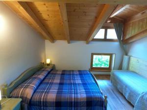 a bedroom with a bed in a room with wooden ceilings at Agriturismo al Marter in Ledro