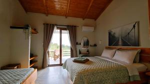 a bedroom with a bed and a sliding glass door at Liokorni Village in Gaios