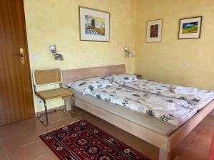 a small bedroom with a bed and a chair at Parco Esotico by HolAp SA in Brissago +36 photos