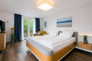 a bedroom with a large bed and a living room at Wohnart - Fewo 1 Wohnstil in Norderney