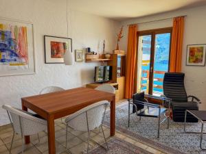 a living room with a wooden table and chairs at Parco Esotico by HolAp SA in Brissago