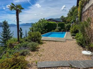 a swimming pool in a garden with a view of the water at Parco Esotico by HolAp SA in Brissago
