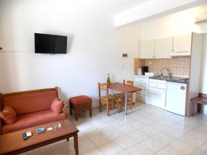 a living room with a couch and a table and a kitchen at Kato Zakros Palace Apartments in Kato Zakros