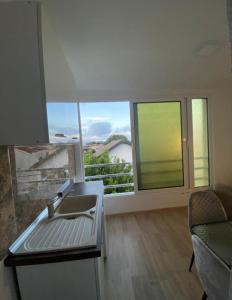 a living room with a sink and two windows at Vila Ideal in Donji Štoj