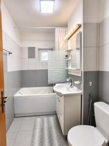 a bathroom with a tub and a toilet and a sink at Adrian Home Libra in Ploieşti +12 photos