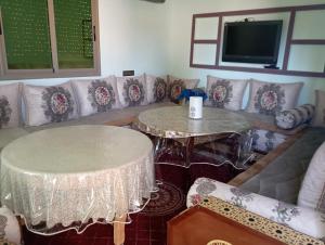 a living room with two tables and a couch at Kaltouma in Sidi Bibi