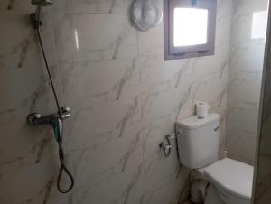a bathroom with a shower with a toilet and a window at Kaltouma in Sidi Bibi