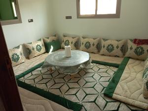 a living room with a couch with a table at Kaltouma in Sidi Bibi