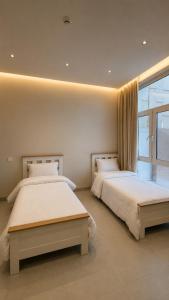 a bedroom with two beds and a window at Seeq view in Sayq +14 photos
