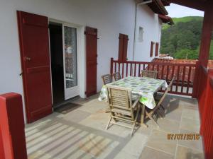 una mesa y sillas en el balcón de una casa en Etxexuriko Borda, en Aïnhoa