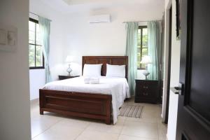 a bedroom with a large bed with white sheets and pillows at Tamarindo Village in San Carlos