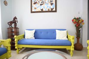 a living room with a blue couch and a vase of flowers at Tamarindo Village in San Carlos