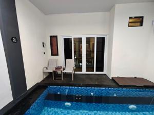 a house with a swimming pool in a room at AIRO Villas in Sultan Syarif Kasim II International Airport