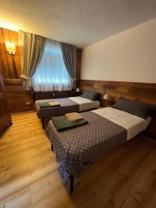 a hotel room with two beds and a window at Chalet Blanc le Refuge in Courmayeur