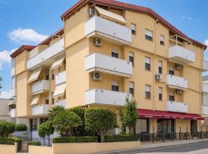 a large yellow building with white balconies at White Charme Rooms -Self Check in- in Alghero