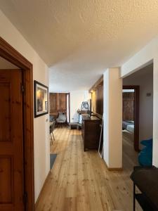 a living room with a wooden floor and a bedroom at Chalet Blanc le Refuge in Courmayeur +8 photos