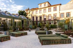 a group of beds in a courtyard with buildings at chic&basic Tokyo Hoose in Porto